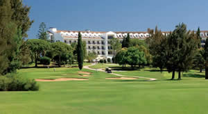 golfers drive their buggies towards the penina golf resort hotel